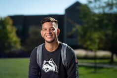 Smiling student in front of Hayes Hall at IU East.